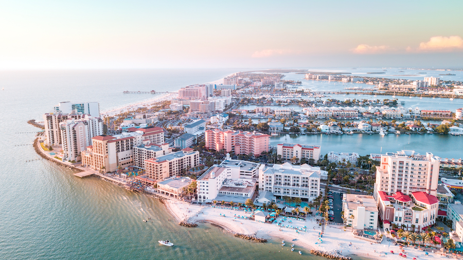 Panorama of city Clearwater Beach FL. Summer vacations in Florida. Beautiful View on Hotels and Resorts on Island. Blue color of Ocean water. American Coast or shore Gulf of Mexico. Sky after Sunset.